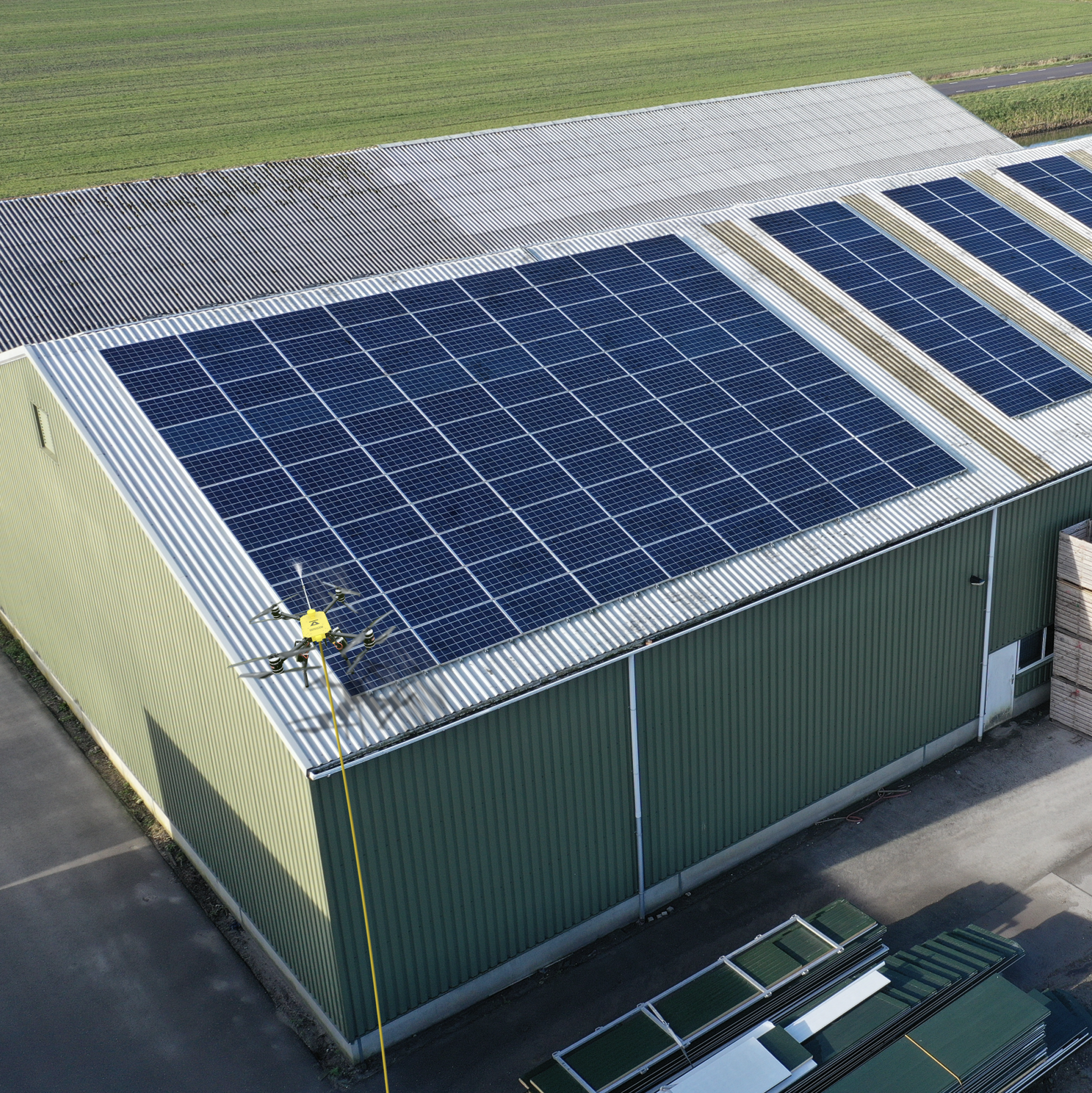 Image of drone cleaning roof of factory with solar panels on it