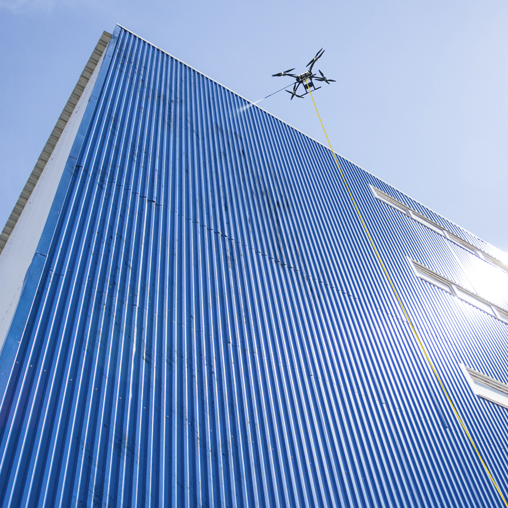 Image of a drone cleaning the facade of a commercial storage facility.